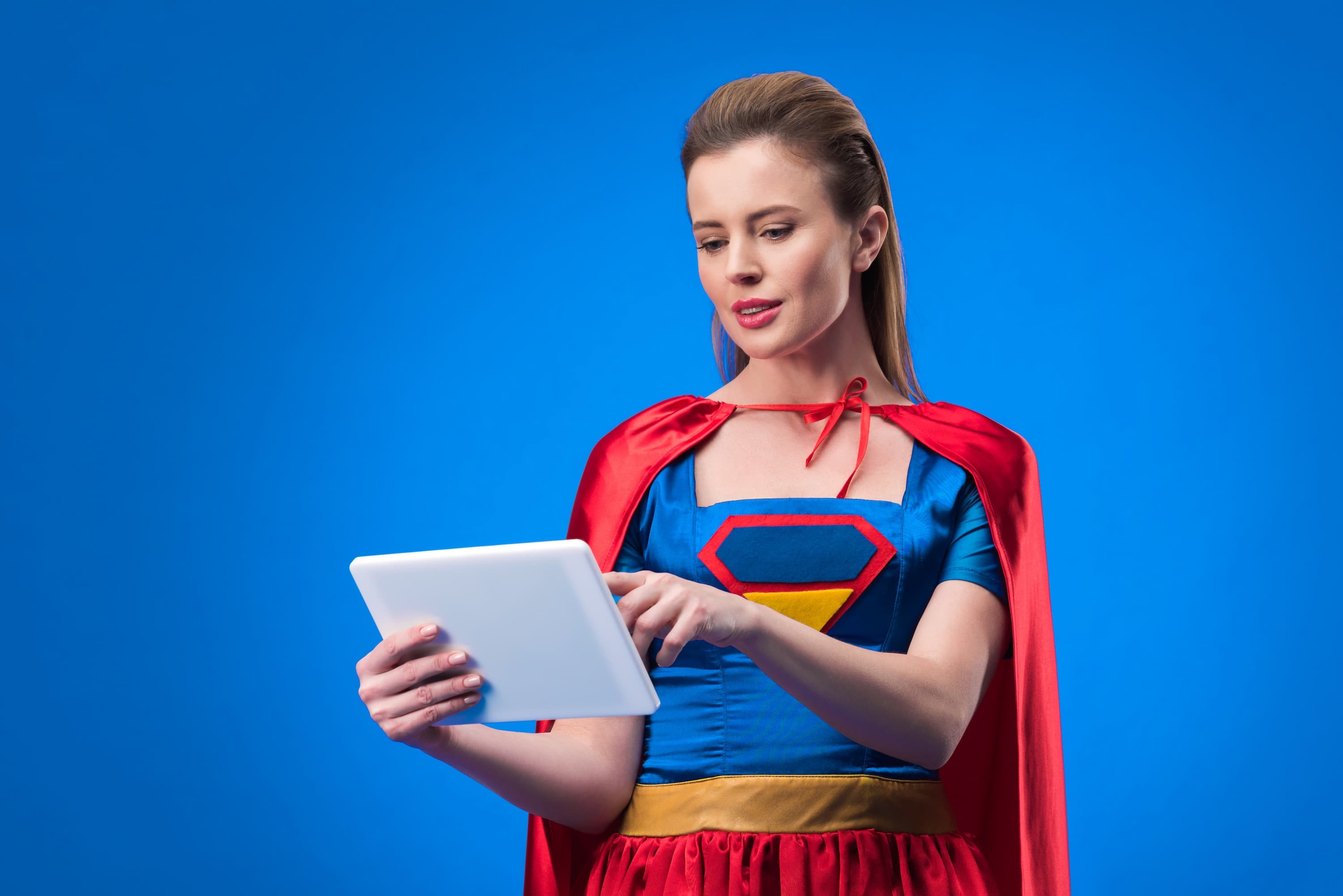 A practitioner in a superhero costume checking her practice numbers on a tablet.
